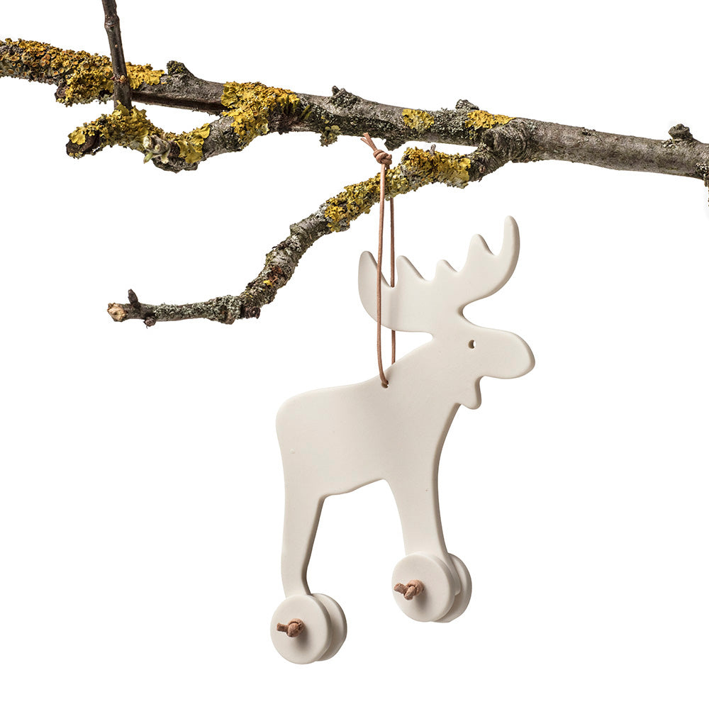 Ornament, pynt til ophæng formet som en elg med hjul og lædersnørre - designet af Louise Heisel