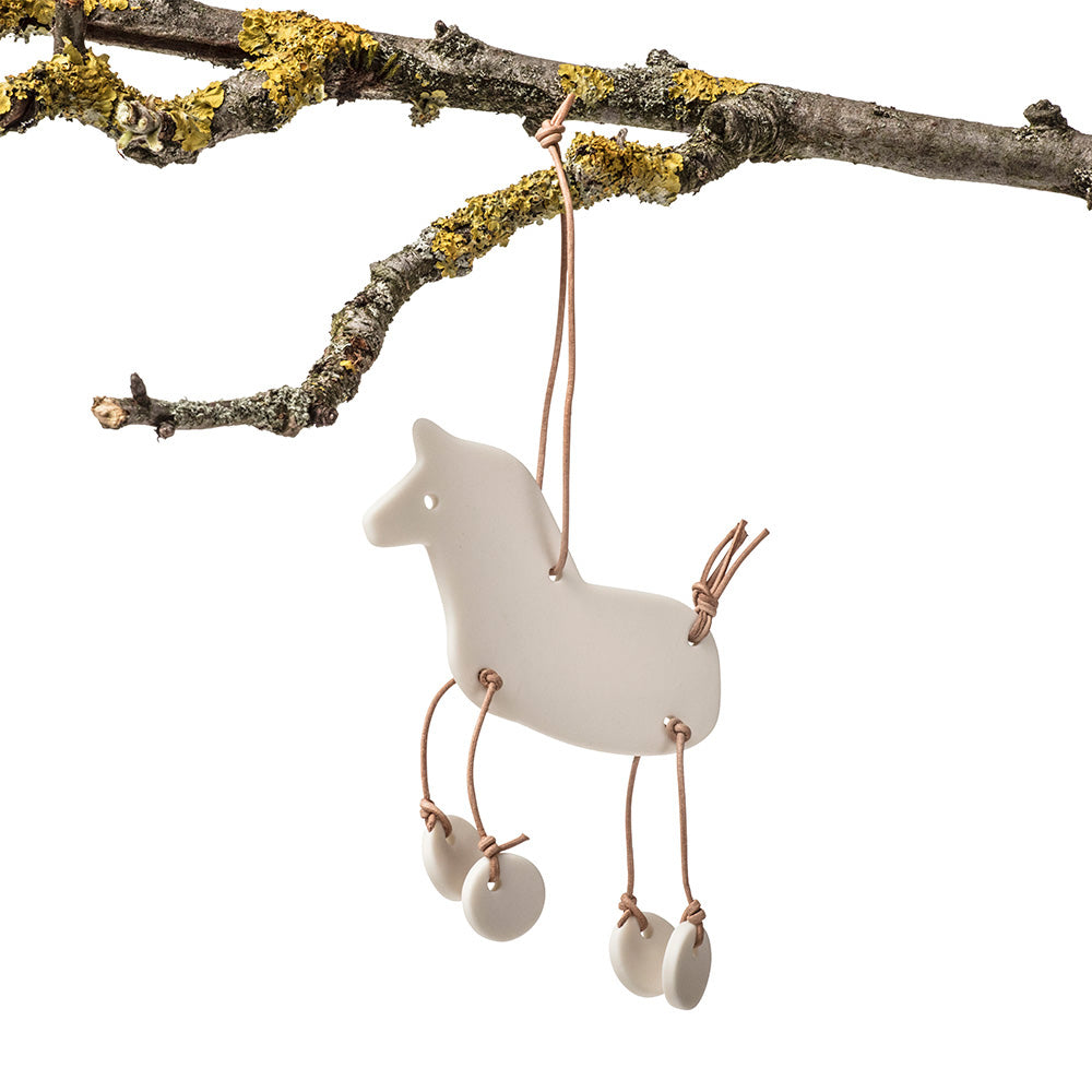 Ornament, pynt til ophæng formet som en hest med dingleben og lædersnørre - designet af Louise Heisel